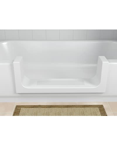 The ORCA TubCut converts standard tubs into walk-in showers with a large U-shaped cutout for easy entry, shown here in white against a tiled wall with a beige and brown woven bath mat on the floor.
