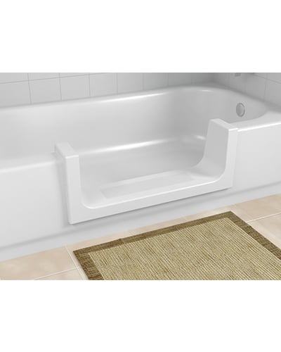 The ORCA TubCut converts a standard bathtub into a walk-in shower with a side entrance, shown here against tiled walls with a beige rug placed in front.